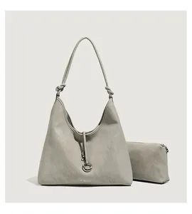 Detail van grijze hobo tas met bijpassende pouch en knoopdetail aan de riem