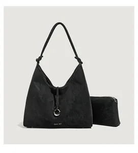 Detail van zwarte suède hobo-tassenset met zilveren ring en kleine ritsportemonnee