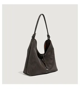 Detailweergave van donkerbruine lederen hobo-tas met geknoopte riem en metalen ring
