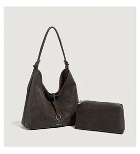 Detail van minimalistische houtskool tote tas met geknoopte riem en ritszakje