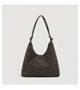 Detail van de geknoopte schouderband en getextureerd leer op deze grote hobo-tas voor dames