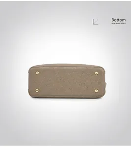 Detail view of the taupe pebble leather handbag bottom with four golden protective feet