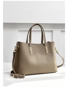 Close-up of litchi texture leather tote bag with elegant gold buckle and adjustable strap