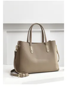 Detail of taupe pebbled leather tote featuring gold hardware and adjustable strap