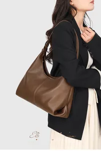 Detail of dark brown pebble leather hobo bag with wide strap for business casual look
