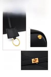 Detailed close-up of golden metal hardware and buckle on a black leather tote bag