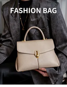 Close-up of beige lychee grain leather tote bag with elegant gold metal buckle and handle