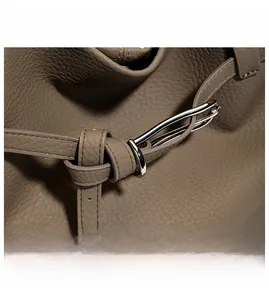 Detail of taupe lychee leather tote bag with silver hardware and drawstring texture