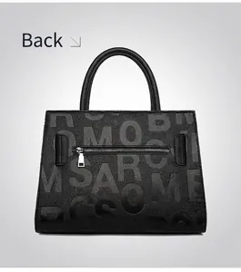 Detail view of the black tote bag's back zipper pocket and lychee pattern leather texture