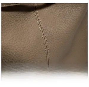 Close-up of brown litchi pattern leather with precision double stitching on a tote bag
