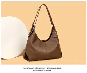 Detail of brown litchi pattern leather tote bag with cute bear charm on beige background