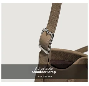 Detail view of adjustable strap with silver buckle on pebble leather tote bag