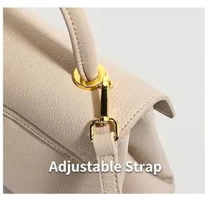 Detail view of lychee pattern leather and gold hardware on adjustable shoulder strap