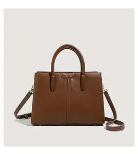 Macro view of brown leather handbag with polished gold hardware and MUSE BAG logo