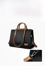 Detail showing the embossed letters and golden hardware on this bicolor tote bag
