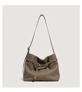 Close-up of taupe tote bag with litchi texture and silver buckle detail on strap