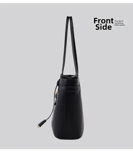 Profile view of a black tote bag showing its structured leather outline and side straps