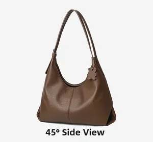 Detail view showing dark brown pebbled leather texture and cute bear charm on hobo bag