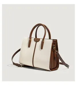Detail of contrast color handbag with cream leather panel and brown side accordion layers