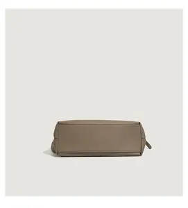 Detailed close-up of taupe tote bag bottom with litchi grain leather and neat stitching
