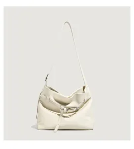 Detail of lychee pattern leather tote bag with silver buckle and smooth cream finish