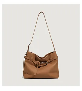 Detail of brown litchi pattern leather tote bag with silver buckle and adjustable strap
