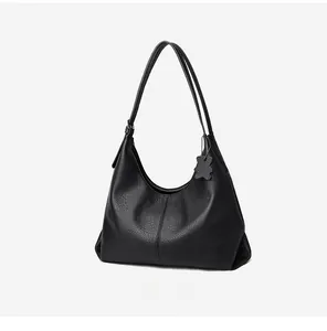 Detail view of 45-degree angle showing black lychee grain leather tote bag texture
