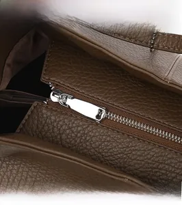 Detailed close-up of premium lychee grain leather tote bag with silver metal zipper