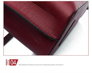 Close-up of durable stitching and black edge oil finish on red leather tote bag