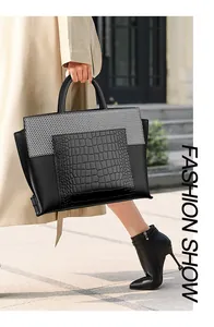 Close-up of black crocodile pattern leather tote bag with mesh panel and sturdy handles