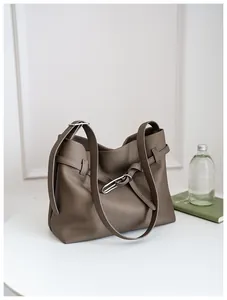 Detail of dark brown pebble leather tote bag with silver buckle and wide shoulder straps