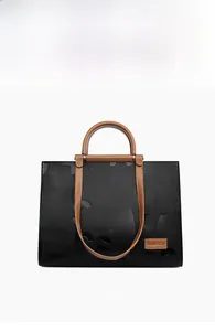 Front view of black pebble leather tote bag with brown handles and embossed letters