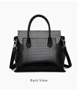 Detail view of the black tote bag back side showing crocodile texture and metal accents