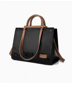 Detail of embossed lettering on black and brown contrast tote bag with leather strap