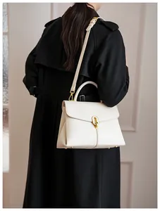 Detailed macro view of white lychee pattern leather handbag with gold twist lock