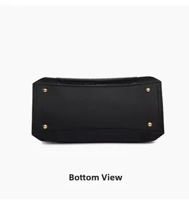 Detail view of the black tote bag bottom with crocodile pattern and golden metal studs