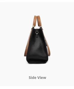 Detail view showing side profile of black tote bag with brown handles and metal D-ring