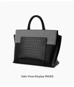 Detail view of black tote bag showing crocodile texture, honeycomb mesh, and lychee grain leather