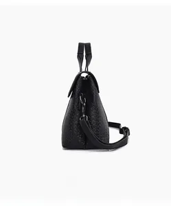 Side view of black woven texture tote bag with silver hardware and shoulder strap