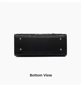 Detail of black pebbled leather tote base with four protective gold metal feet and embossing