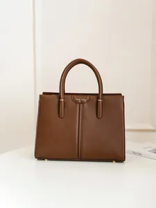 Classic dark brown leather tote bag with gold Muse Bag logo in a minimalist setting