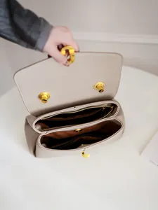Women's chic beige lychee leather tote with gold hardware and spacious interior