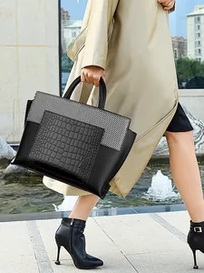 Chic black and white tote bag with faux crocodile texture shown in a street style view