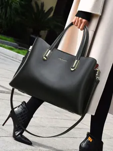 Classic black leather tote bag with LEMON KOKO logo and gold hardware on a street model