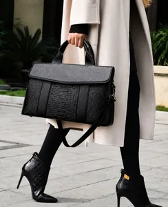 Chic black leather tote bag with animal texture panels shown in an outdoor street style