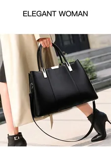 Details einer schwarzen Ledertasche mit goldfarbenen Schlössern und abnehmbarem Schultergurt
