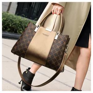 Outdoor-Aufnahme einer Luxus-Tote-Tasche mit braunem Karomuster und goldenem Leder
