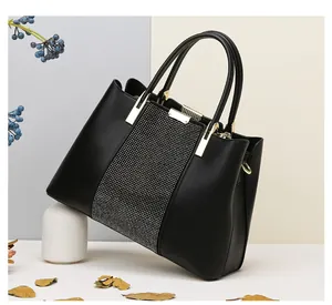 Detailansicht der schwarzen Handtasche mit silbernem Strassbesatz und goldenen Griffen