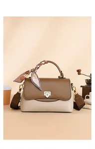 Détail du sac bandoulière bicolore avec poignée en foulard et texture cuir grainé