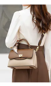 Détail du sac bandoulière bicolore avec poignée en soie et large sangle textile